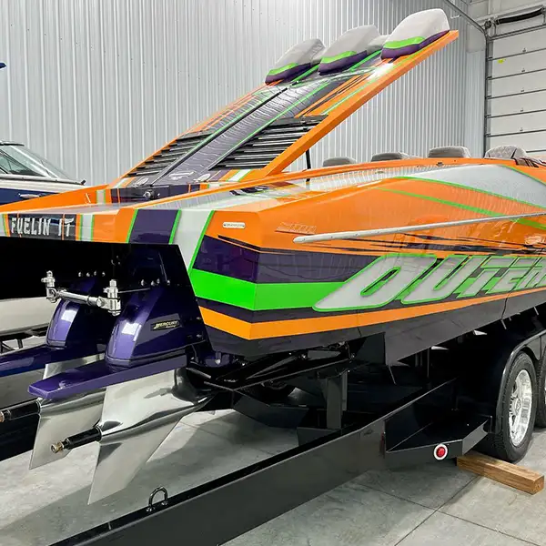 Boat out of water for appraisal survey. Orange, green, white and purple striped powerboat on black trailer. 2015 Outerlimits SL-41 Powerboat in Grand Haven.